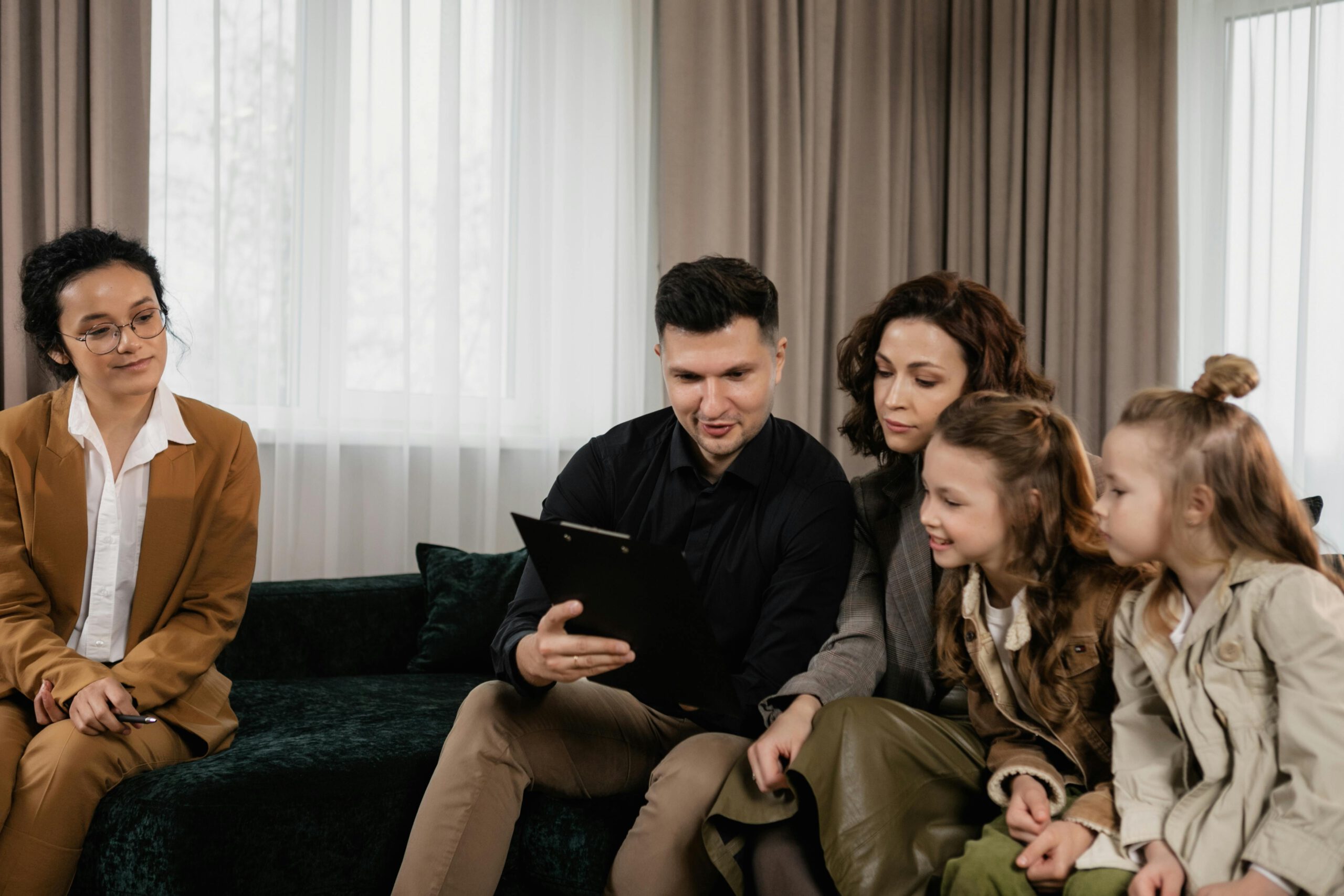 A family receiving advice from a professional advisor indoors, focused on financial planning.
